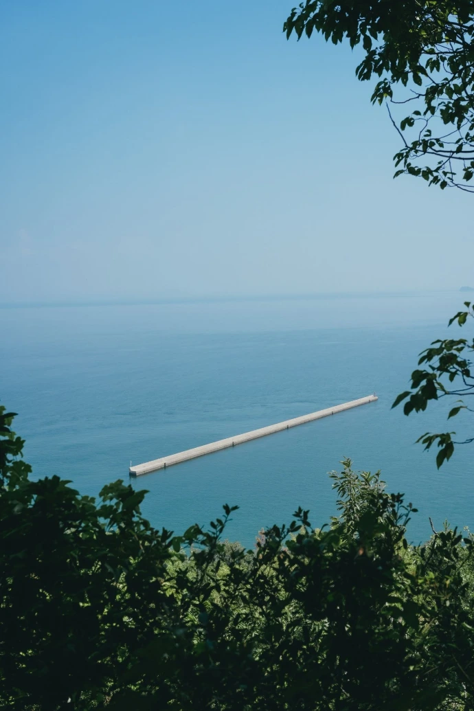 Long floating structure on calm blue ocean water